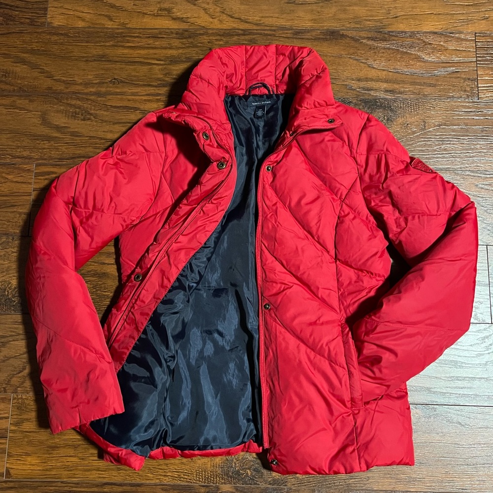 Red puffer jacket with navy blue lining.